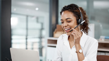 Woman in a call center, smiling and talking on the phone